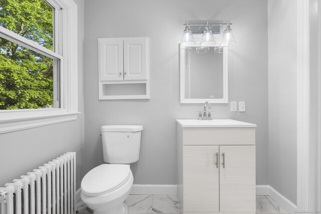 37 View St, East Haven, CT 06512 - half bathroom with radiator heating unit, marble look tiles, vanity, baseboards, and toilet
