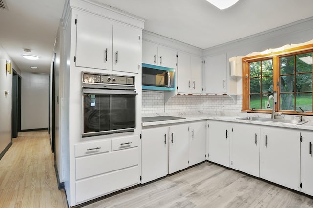 86 Rice Rd, Meriden, CT 06450 - kitchen with oven, a sink, light countertops, black electric cooktop, and decorative backsplash