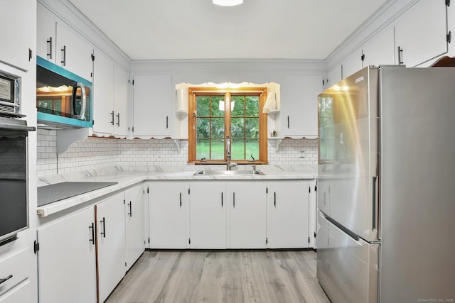 86 Rice Rd, Meriden, CT 06450 - kitchen with stainless steel appliances, light wood finished floors, tasteful backsplash, white cabinets, and ornamental molding