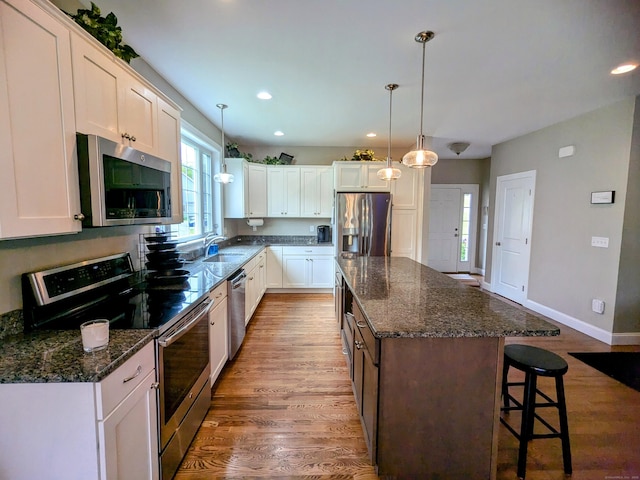 5 Newberry St, Haddam, CT 06441 - kitchen with stainless steel appliances, wood finished floors, a center island, a breakfast bar area, and white cabinetry