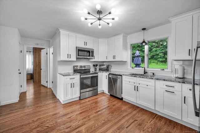 75 Carll Rd, Middletown, CT 06457 - kitchen with stainless steel appliances, a sink, a chandelier, and wood finished floors