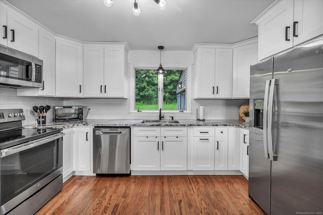 75 Carll Rd, Middletown, CT 06457 - kitchen featuring appliances with stainless steel finishes, a sink, stone counters, white cabinets, and backsplash