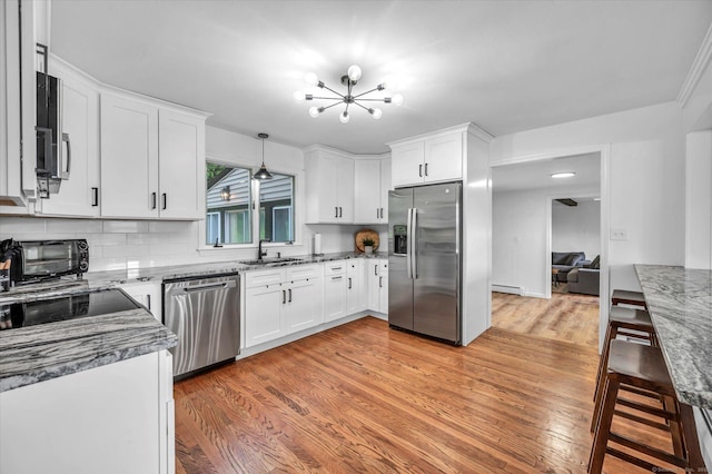 75 Carll Rd, Middletown, CT 06457 - kitchen with appliances with stainless steel finishes, a sink, a baseboard heating unit, light wood finished floors, and a chandelier