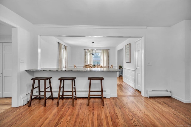 75 Carll Rd, Middletown, CT 06457 - kitchen featuring a baseboard heating unit, a kitchen bar, a baseboard radiator, and light wood-style floors