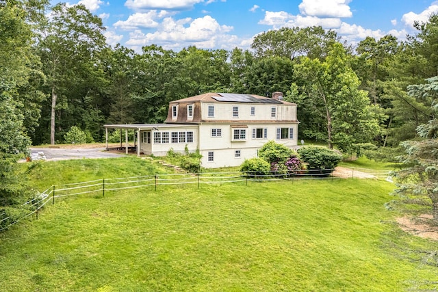29 Daniels Rd, East Haddam, CT 06423 - rear view of house with roof mounted solar panels, a chimney, and a wooded view