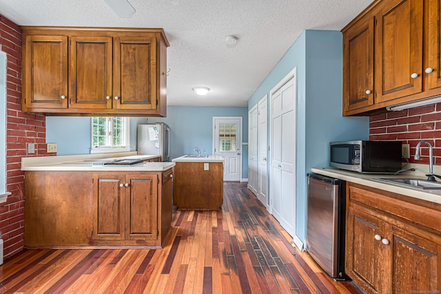 29 Daniels Rd, East Haddam, CT 06423 - kitchen featuring appliances with stainless steel finishes, dark wood finished floors, brown cabinetry, light countertops, and a textured ceiling