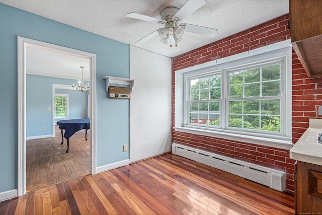 29 Daniels Rd, East Haddam, CT 06423 - empty room featuring a baseboard radiator, wood-type flooring, brick wall, a chandelier, and baseboards