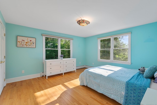 403 Bethmour Rd, Bethany, CT 06524 - bedroom with multiple windows, a baseboard heating unit, wood finished floors, and baseboards