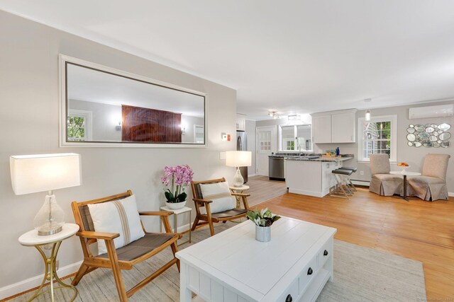 60 Indian Spring Rd, Woodstock, CT 06281 - living room featuring light wood finished floors, a wall mounted AC, and baseboards
