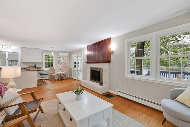 60 Indian Spring Rd, Woodstock, CT 06281 - living area with baseboard heating, light wood-style floors, a wall unit AC, and a brick fireplace