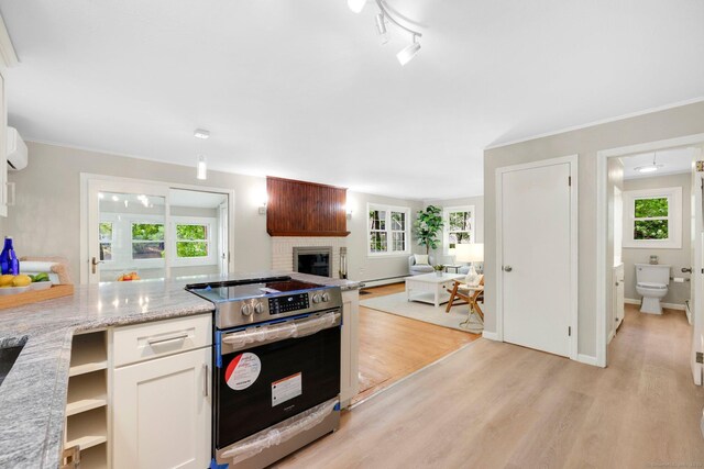 60 Indian Spring Rd, Woodstock, CT 06281 - kitchen featuring stainless steel range with electric cooktop, light wood-style floors, a brick fireplace, healthy amount of natural light, and crown molding