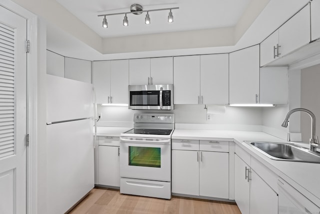 80 Seaview Ter Unit 12, Guilford, CT 06437 - kitchen with white appliances, light countertops, white cabinetry, and light wood finished floors