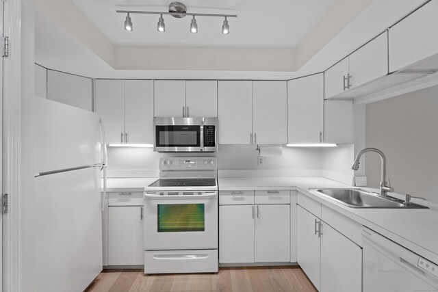 80 Seaview Ter Unit 12, Guilford, CT 06437 - kitchen featuring white appliances, light countertops, white cabinets, and light wood-style flooring