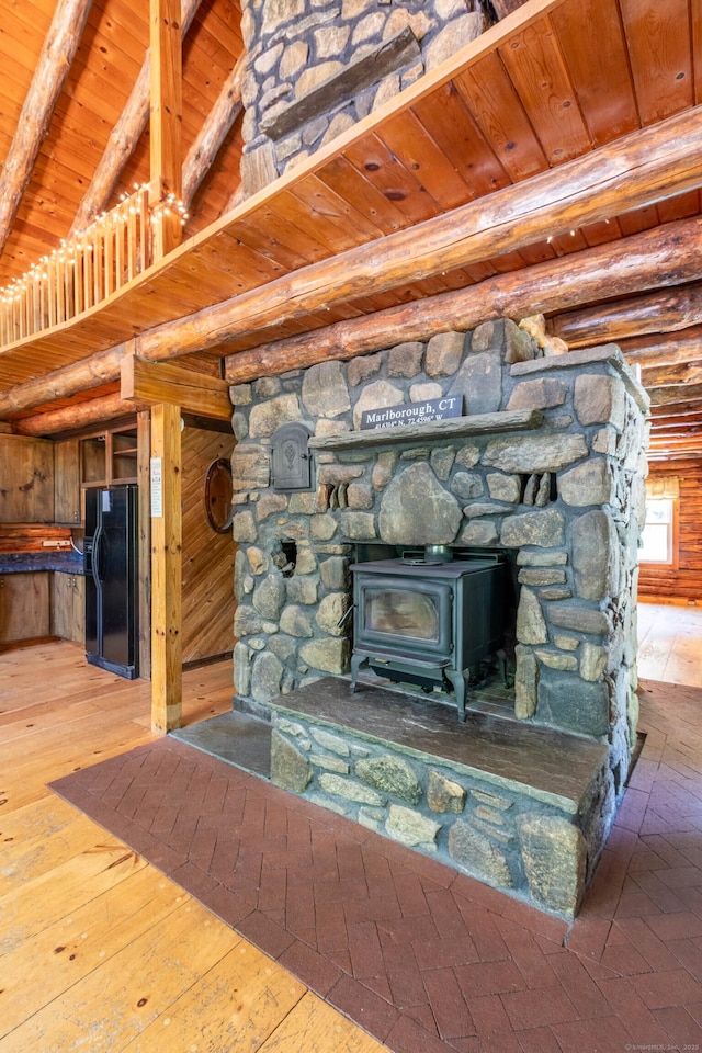 112 Edstrom Rd, Marlborough, CT 06447 - detailed view of wooden ceiling with exposed beams, black fridge, and a wood stove