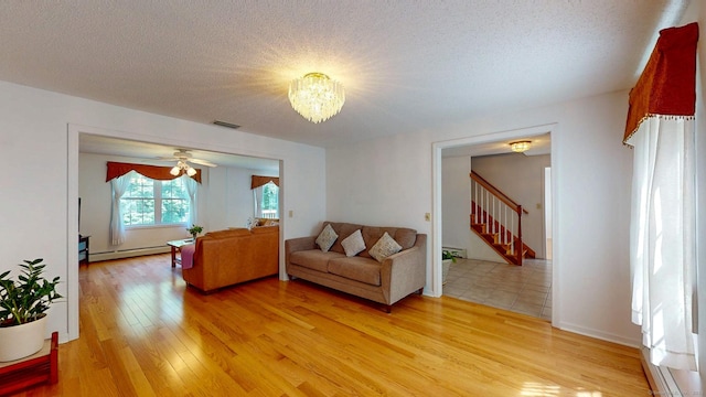 26 Reno Dr, Middletown, CT 06457 - living area with stairs, light wood-type flooring, baseboard heating, a chandelier, and a textured ceiling