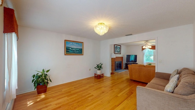 26 Reno Dr, Middletown, CT 06457 - living room featuring light wood-style flooring, a chandelier, a fireplace, and a ceiling fan