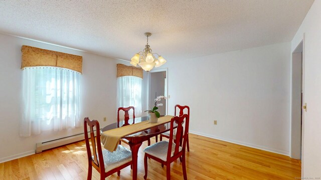 26 Reno Dr, Middletown, CT 06457 - dining area with a baseboard radiator, a chandelier, light wood-style flooring, a textured ceiling, and baseboards