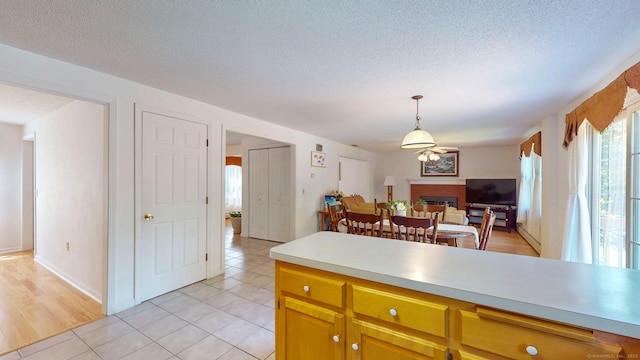 26 Reno Dr, Middletown, CT 06457 - kitchen featuring light countertops, a brick fireplace, hanging light fixtures, open floor plan, and ceiling fan