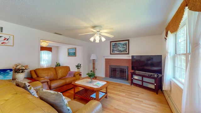 26 Reno Dr, Middletown, CT 06457 - living area featuring light wood finished floors, a fireplace, ceiling fan, and a baseboard heating unit