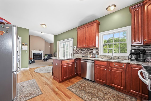 280 Ridgefield Ave, Waterbury, CT 06705 - kitchen with stainless steel appliances, a sink, light wood-type flooring, a peninsula, and a fireplace
