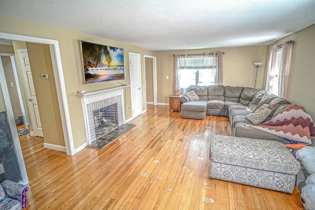 49 Hintz Dr, Wallingford, CT 06492 - living room featuring hardwood / wood-style floors, a tile fireplace, a textured ceiling, and baseboards