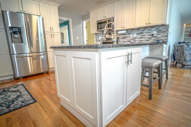 49 Hintz Dr, Wallingford, CT 06492 - kitchen with stainless steel appliances, light wood-style flooring, tasteful backsplash, and white cabinets