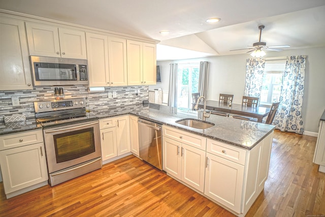 49 Hintz Dr, Wallingford, CT 06492 - kitchen with appliances with stainless steel finishes, a sink, a peninsula, backsplash, and light wood-style flooring
