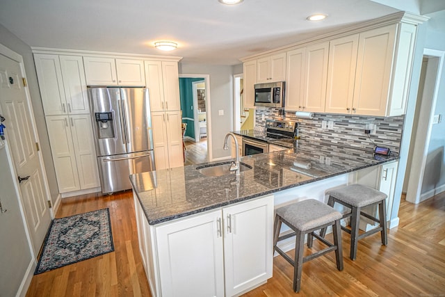 49 Hintz Dr, Wallingford, CT 06492 - kitchen featuring stainless steel appliances, a sink, dark stone counters, a peninsula, and light wood-style floors
