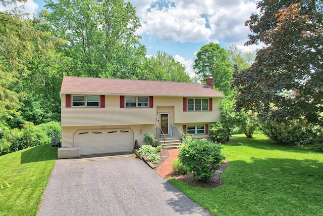 159 Humiston Cir, Thomaston, CT 06787 - split foyer home with a chimney, driveway, an attached garage, a front lawn, and central AC