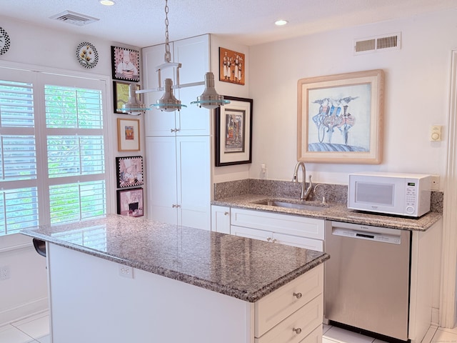 12 Heritage Crst Unit E, Southbury, CT 06488 - kitchen with stainless steel dishwasher, white microwave, white cabinets, stone counters, and recessed lighting