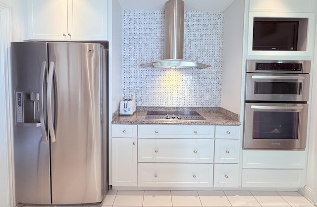 12 Heritage Crst Unit E, Southbury, CT 06488 - kitchen with appliances with stainless steel finishes, wall chimney exhaust hood, white cabinets, and light tile patterned floors