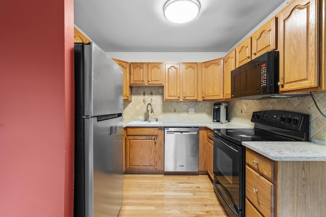 23 Rockmeadow Rd, Norwalk, CT 06850 - kitchen with black appliances, a sink, light countertops, light wood finished floors, and decorative backsplash