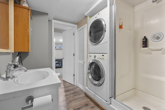 23 Rockmeadow Rd, Norwalk, CT 06850 - washroom featuring stacked washer / dryer, a sink, and wood finished floors