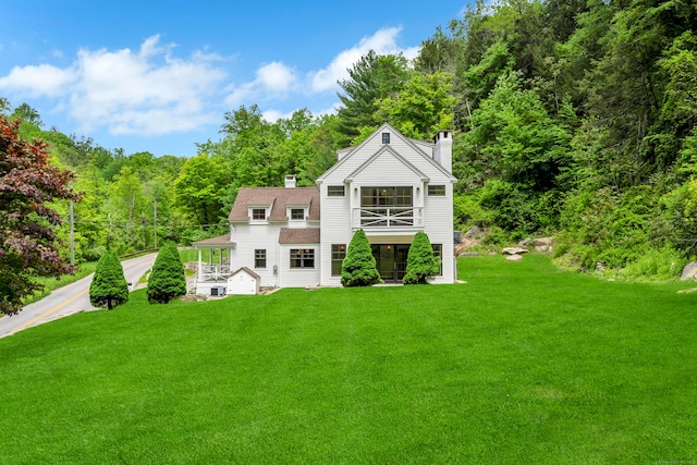 153 Valley Forge Rd, Weston, CT 06883 - view of front of property featuring a chimney, a balcony, a front lawn, and a view of trees