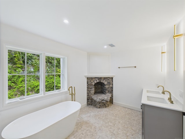 153 Valley Forge Rd, Weston, CT 06883 - full bathroom featuring a freestanding bath, double vanity, a fireplace, baseboards, and recessed lighting