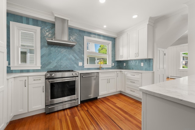 46 Park St, New London, CT 06320 - kitchen featuring stainless steel appliances, wall chimney exhaust hood, light wood finished floors, crown molding, and white cabinetry