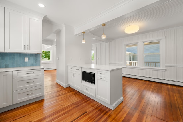 46 Park St, New London, CT 06320 - kitchen featuring baseboard heating, ornamental molding, light countertops, light wood finished floors, and a peninsula