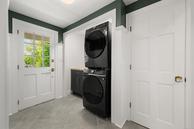 46 Park St, New London, CT 06320 - washroom with stacked washing machine and dryer, cabinet space, and light tile patterned flooring