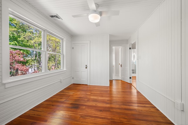 46 Park St, New London, CT 06320 - unfurnished bedroom with hardwood / wood-style floors, a ceiling fan, and wooden walls