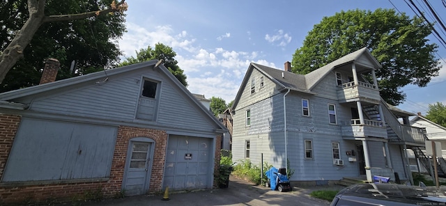 48 Brookside Ave, Torrington, CT 06790 - view of front of house with a balcony, a chimney, and brick siding