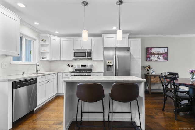 92 Lafayette St Apt 5, Stamford, CT 06902 - kitchen with stainless steel appliances, ornamental molding, a breakfast bar area, white cabinets, and a kitchen island