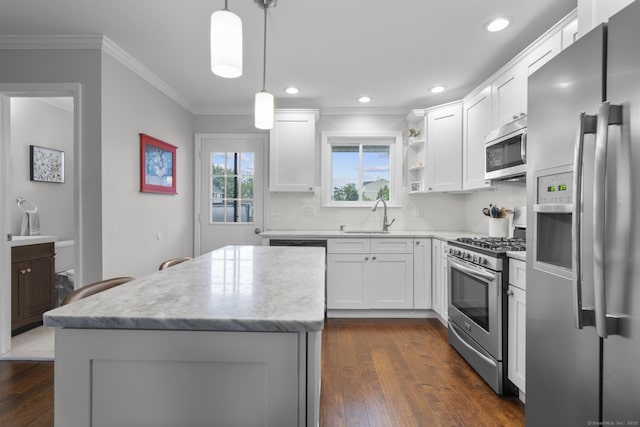 92 Lafayette St Apt 5, Stamford, CT 06902 - kitchen with appliances with stainless steel finishes, a kitchen island, dark wood finished floors, crown molding, and white cabinetry