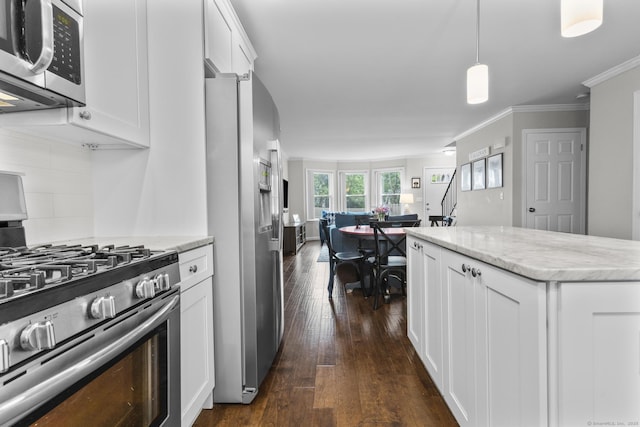 92 Lafayette St Apt 5, Stamford, CT 06902 - kitchen with appliances with stainless steel finishes, dark wood finished floors, white cabinets, light stone countertops, and hanging light fixtures