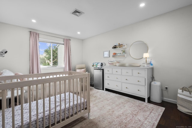 92 Lafayette St Apt 5, Stamford, CT 06902 - bedroom featuring a crib, recessed lighting, wood finished floors, and freestanding refrigerator