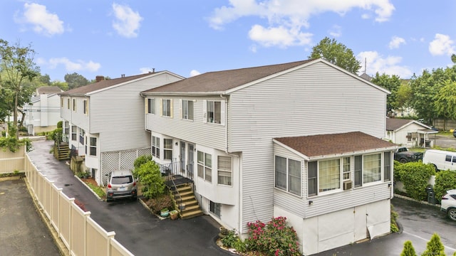 92 Lafayette St Apt 5, Stamford, CT 06902 - view of property exterior featuring a fenced backyard, a shingled roof, and stairs