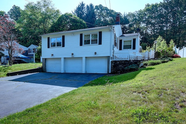 673 May St, Naugatuck, CT 06770 - view of front facade featuring a chimney, driveway, a front yard, and a garage
