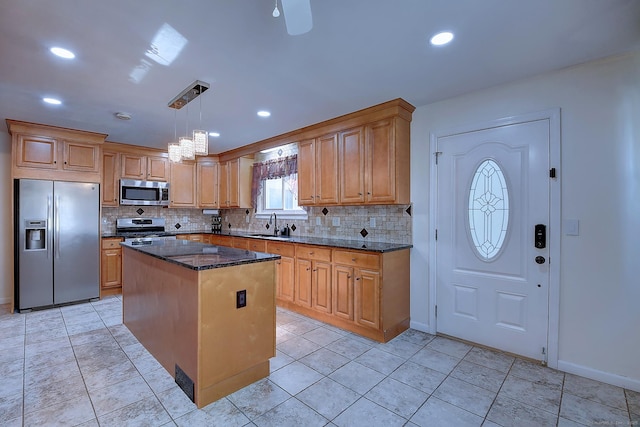 673 May St, Naugatuck, CT 06770 - kitchen featuring appliances with stainless steel finishes, backsplash, a center island, dark stone counters, and recessed lighting