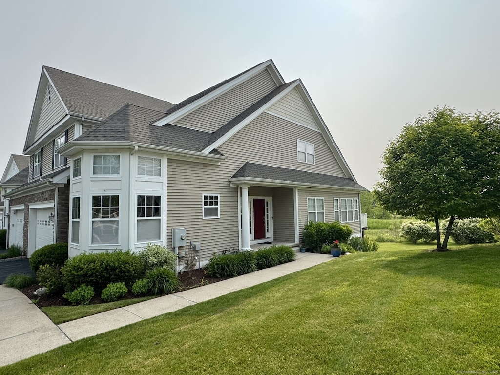 22 Pebble Beach Dr Unit 22, Bloomfield, CT 06002 - view of front of home with a shingled roof and a front lawn