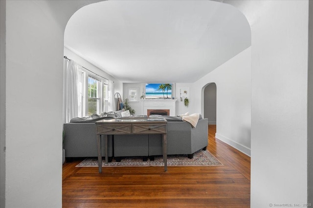 17 Wild Rose Pl, Waterford, CT 06385 - living room featuring arched walkways, a fireplace, wood finished floors, and baseboards