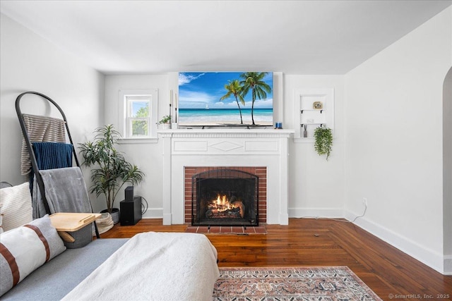 17 Wild Rose Pl, Waterford, CT 06385 - living area featuring baseboards, a brick fireplace, wood finished floors, and built in shelves